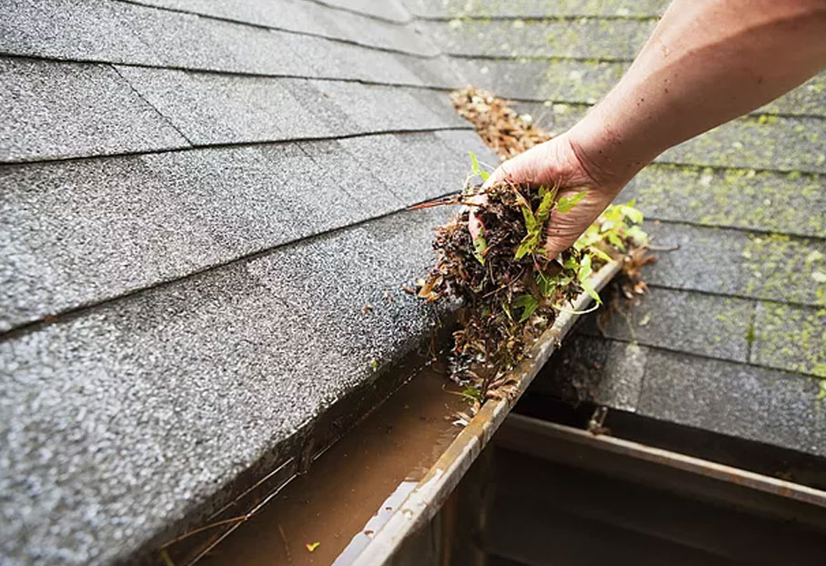 Technician cleaning gutters on a Calgary home